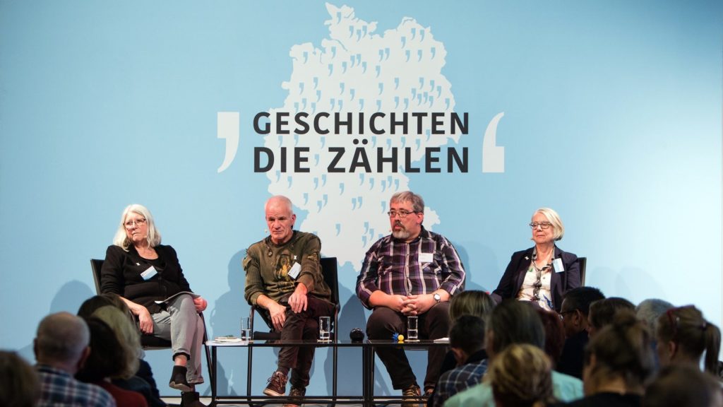 Vier Menschen sitzen auf einer Bühne. Betroffene von sexuellem Missbrauch in der DDR erzählen ihre Geschichte.
