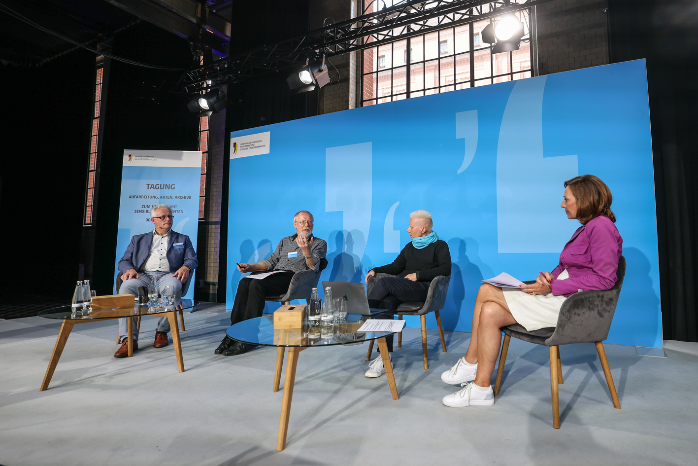 Vier Personen sitzen im Halbkreis auf einer Bühne und sprechen miteinander. Von links nach rechts sind das Johannes Kistenich-Zerfaß, Heiner Keupp, Angela Marquardt und die Moderatorin Juliane Hielscher.
