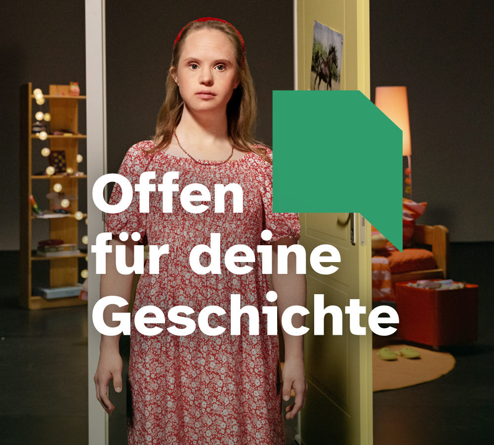 Motiv der Kampagne "Offen für deine Geschichte": Eine junge Frau mit Down-Syndrom steht im Zentrum des Fotos. Sie ist blond und hat ein rot-weiß geblümtes Kleid an. Im Hintergrund eine Theaterkulisse mit geöffneter Gelber Tür. Dahinter ist die Einrichtung eines Kinderzimmers zu erkennen. Darauf Text: "Offen für deine Geschichte" und Logo offene Tür