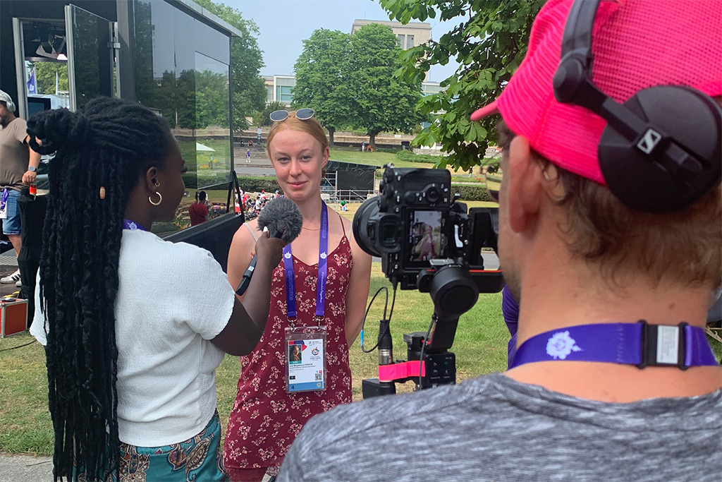 Videoproduktion bei den Special Olympics: Moderatorin Kelly Boachie im Gespräch mit einer Besucherin. Von hinten zu sehen der Kameramann.
