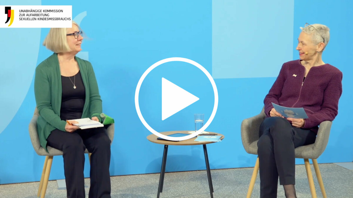 Thumbnail des Videos vom Schlusswort: Auf einer Bühne mit blauem Hintergrund sitzen Barbara Kavemann und Moderatorin Beate Hinrichs