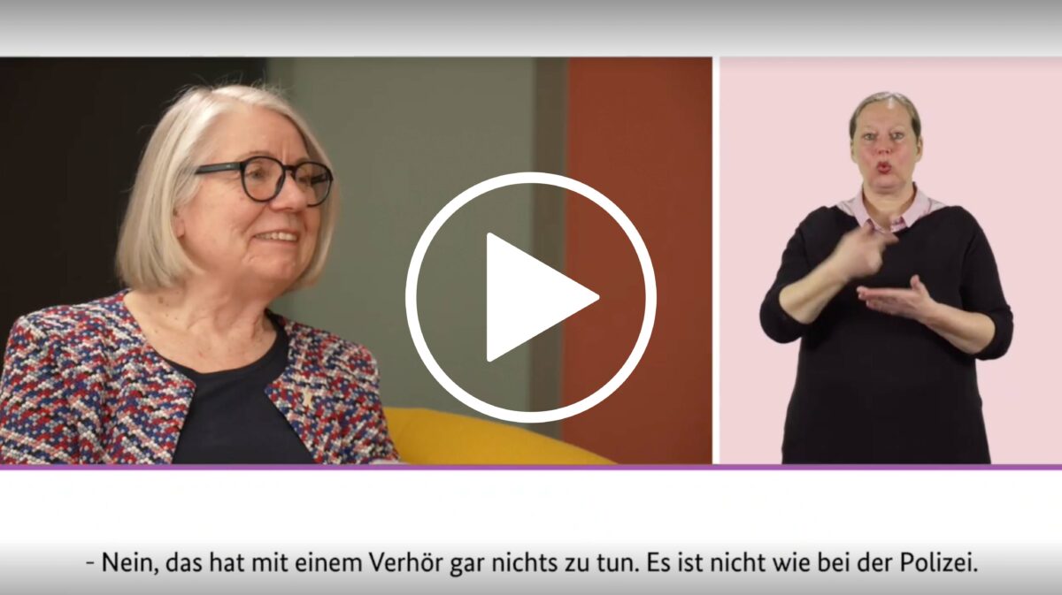 Video-Thumbnail: Links Kommissionsmitglied Barbara Kavemann, rechts Gebärden-Dolmetscherin, unten Untertitel: "Nein, das hat mit einem Verhör gar nichts zu tun. Es ist nicht wie bei der Polizei."